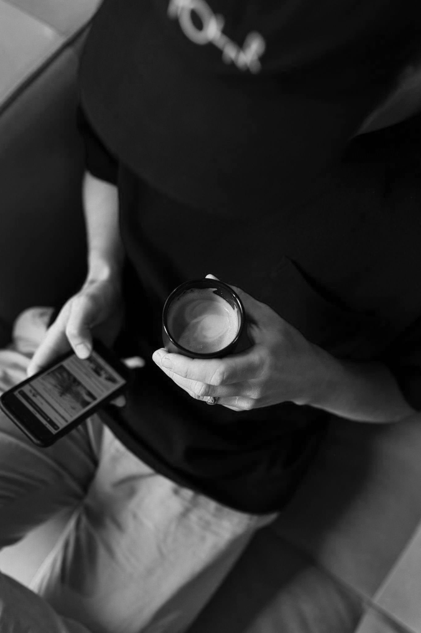 Man drinking coffee while looking at mobile phone